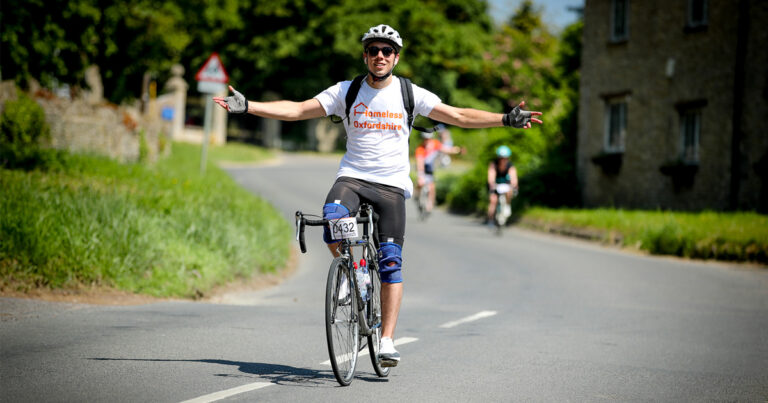 Matt is wearing a Homeless Oxfordshire T-shirt whilst on his bike, completing Bike Oxford